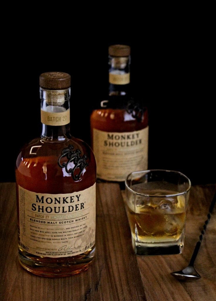 Φιάλες whisky και ποτήρι σε ξύλινο τραπέζι