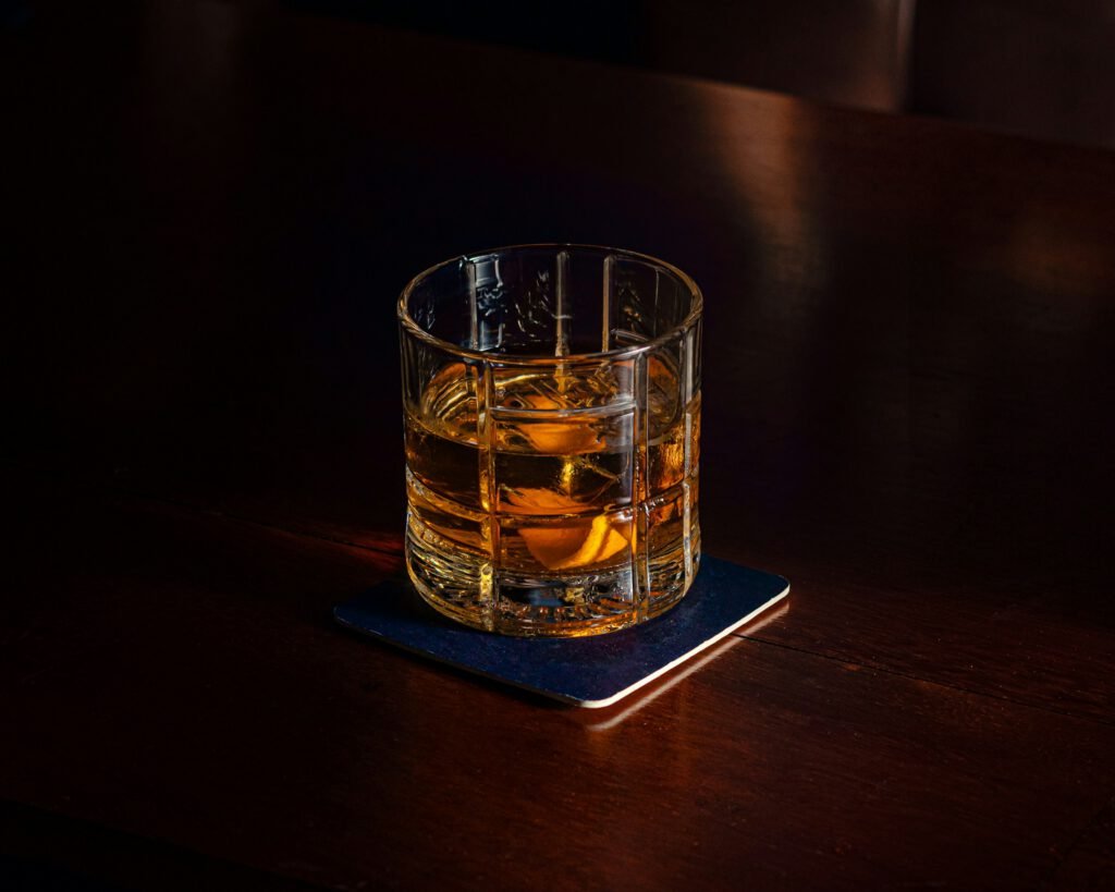 Ποτήρι whisky σε σκούρο ξύλινο τραπέζι